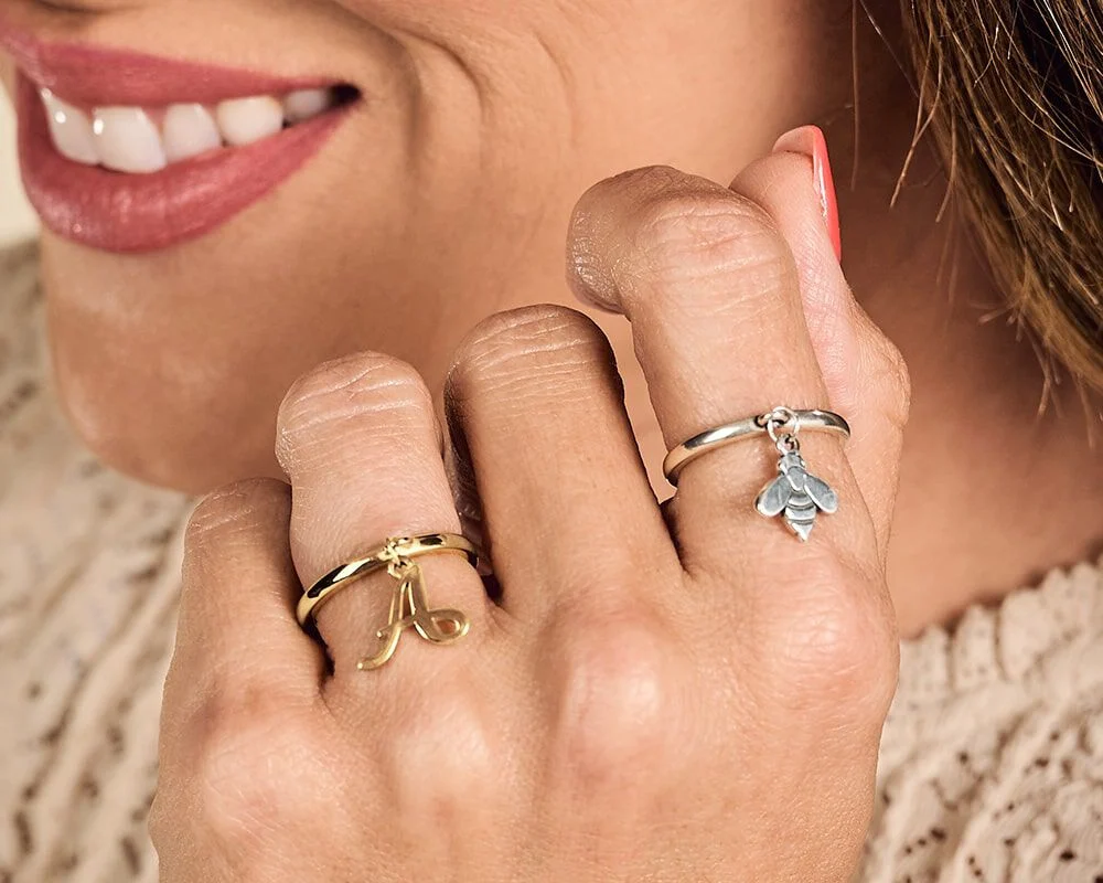 Sterling silver and gold rings on a hand.