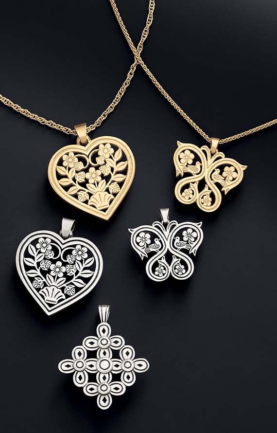 Eloquent heart-, butterfly-, and cross-shaped pendants in sterling silver and 14K gold on a black background